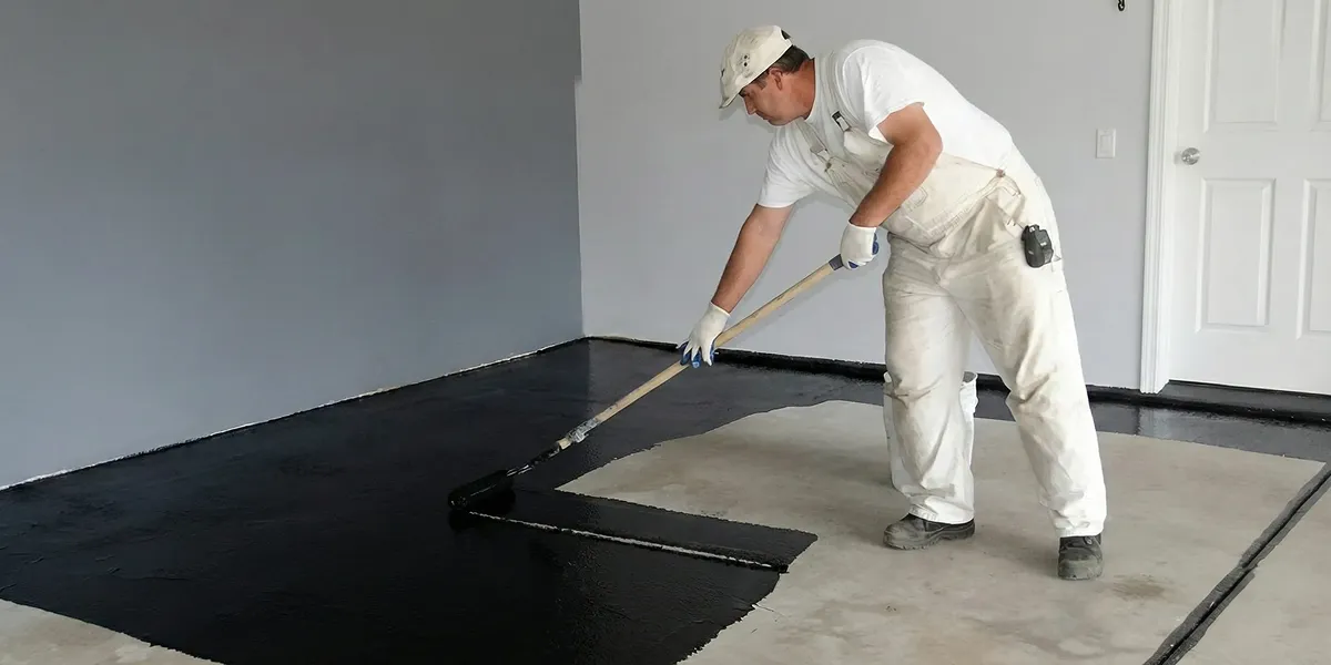 basement waterproofing professional applying waterproof coating to protect a basement floor in Detroit, MI