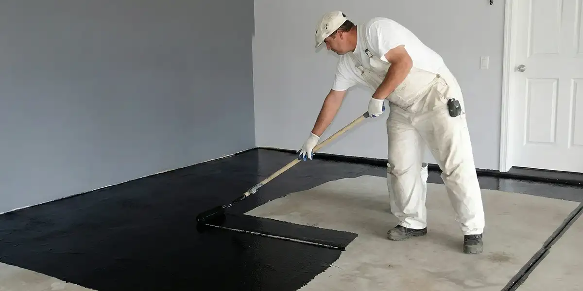 basement waterproofing professional applying waterproof coating to protect a basement floor in Detroit, MI